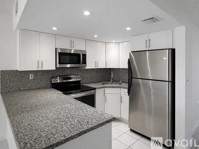 A kitchen with a granite countertop and stainless steel appliances.