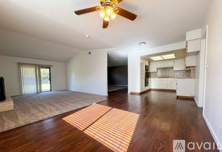 A living room with a ceiling fan and a television.