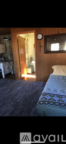 A bedroom with a bed and a mirror on the wall.