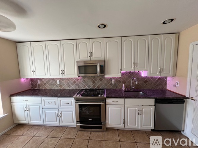 A kitchen with white cabinets and a black stove top oven.