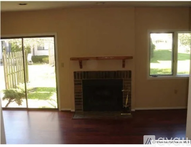 A living room with a fireplace and sliding glass doors.