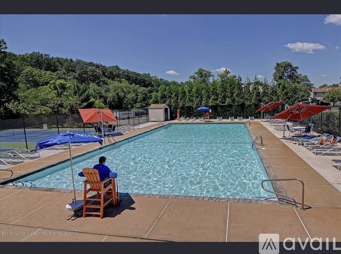 A man is sitting on a chair by a pool.