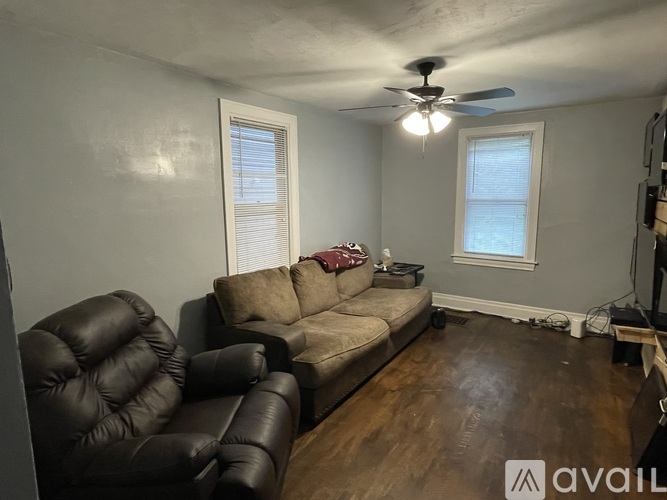 A living room with a black leather chair and a brown sofa.