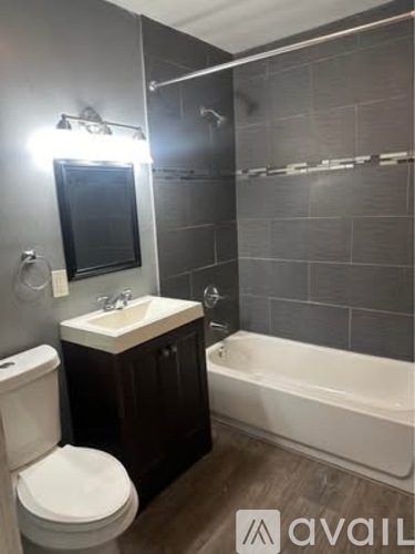 A bathroom with a white toilet, a sink, and a bathtub.