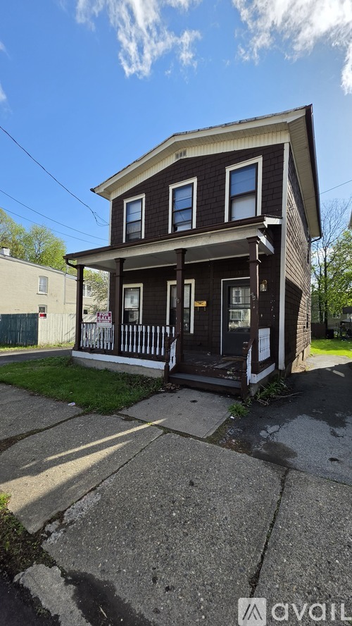 A two-story house with a black front porch and white trim.