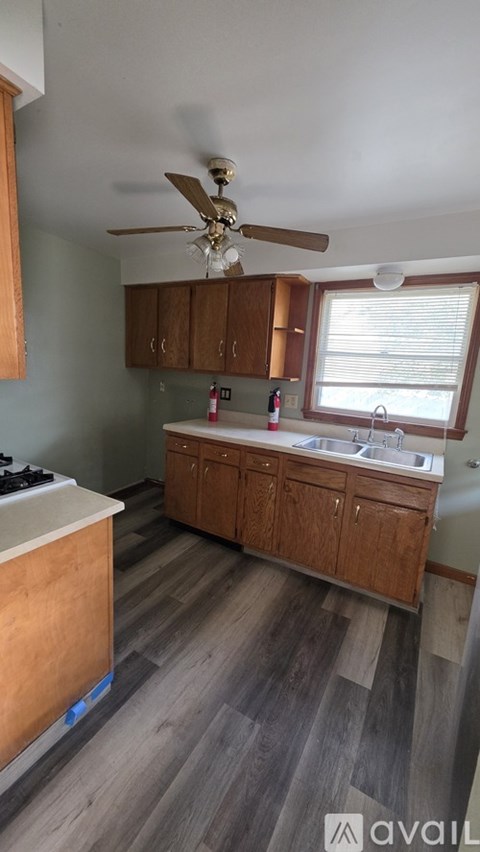 A kitchen with wooden cabinets and a ceiling fan.