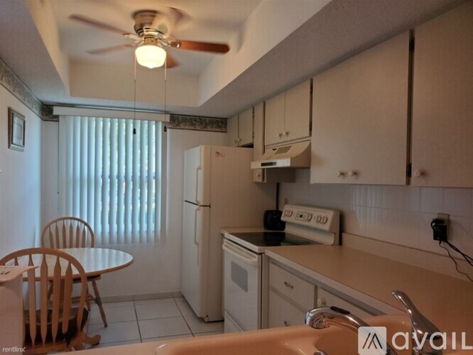 A kitchen with a table and chairs and a fan.