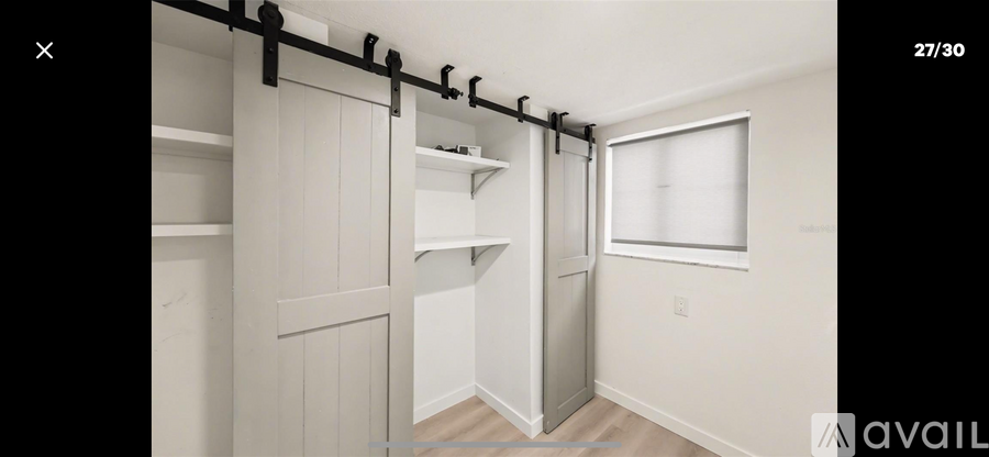A white closet with a sliding door and shelves.