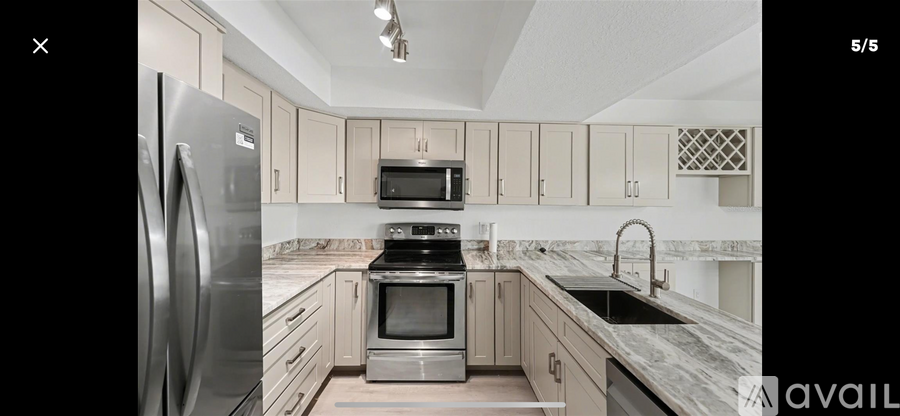 A modern kitchen with a stainless steel refrigerator and oven.