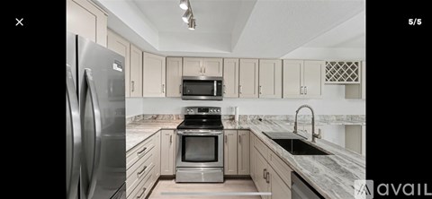 A modern kitchen with a stainless steel refrigerator and oven.