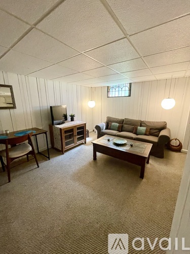 A living room with a couch, chair, and television.