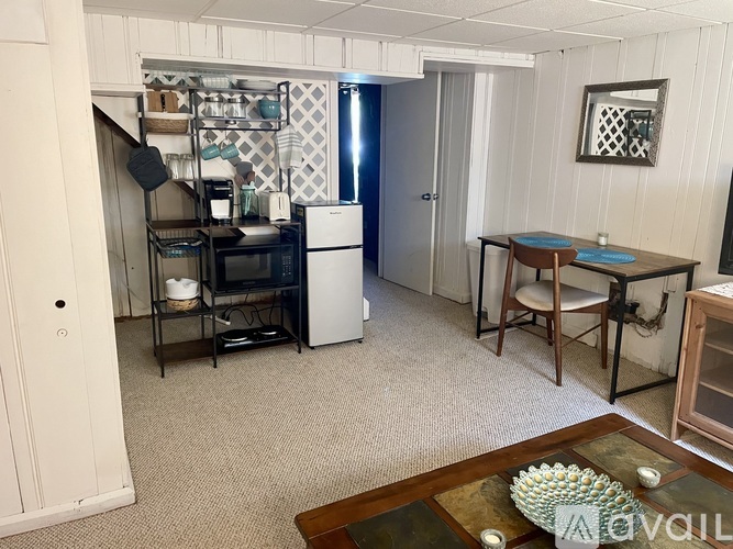 A kitchen area with a refrigerator, a stove, and a dining table.