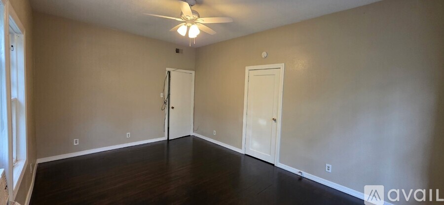 A room with a fan and two doors.