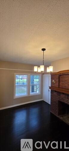 A room with a chandelier and a fireplace.