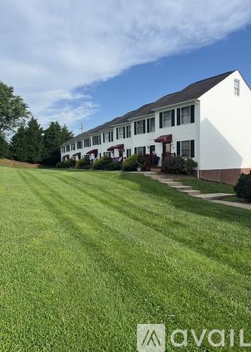 A white house with a green lawn in front.