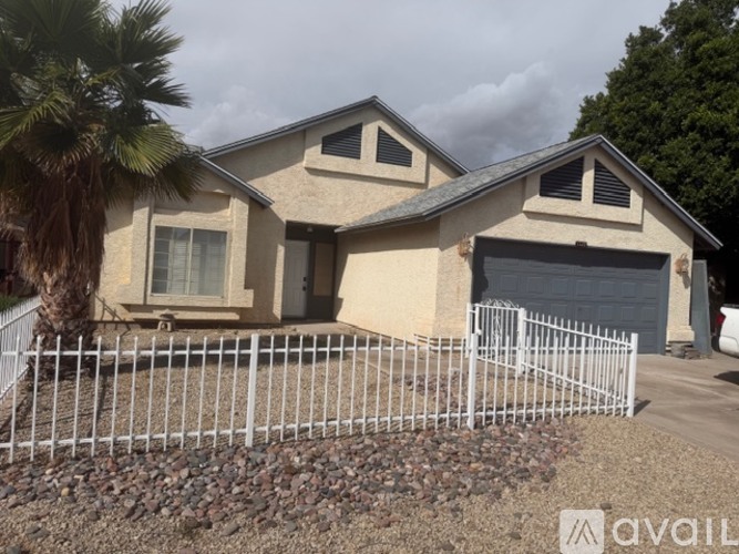 A house with a white fence and a garage door.