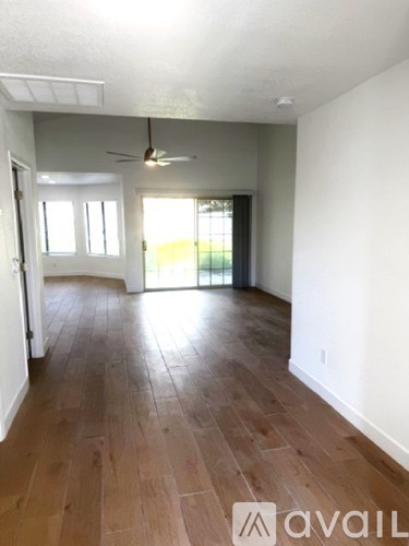 A room with wooden flooring and a ceiling fan.