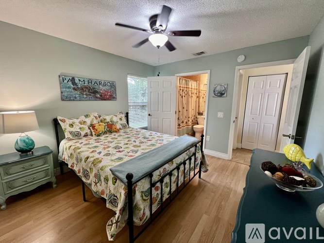 A bedroom with a bed, dresser, and ceiling fan.