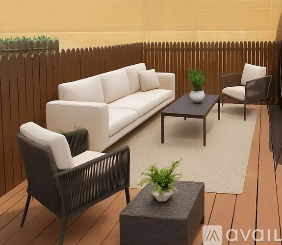 A patio with a white couch, two chairs, and a coffee table.