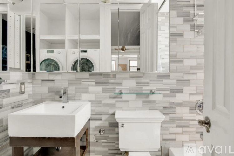 A modern bathroom with a white sink and a white toilet.
