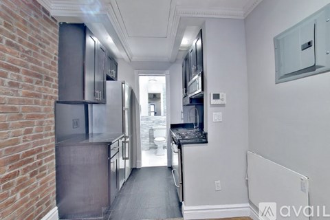 A kitchen with a brick wall and stainless steel appliances.