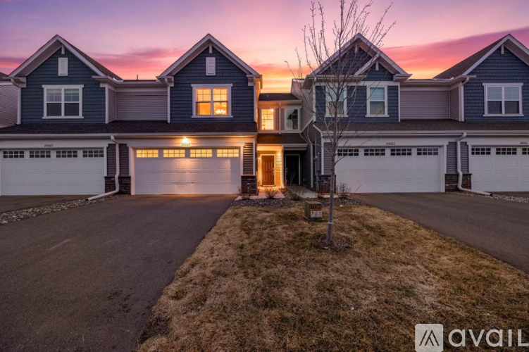 A house with a driveway and garage doors is available for sale.