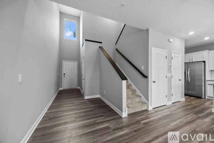 A spacious living room with a staircase leading to the upper level.