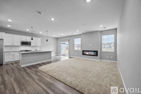 A spacious kitchen with white cabinets and a beige rug on the floor.