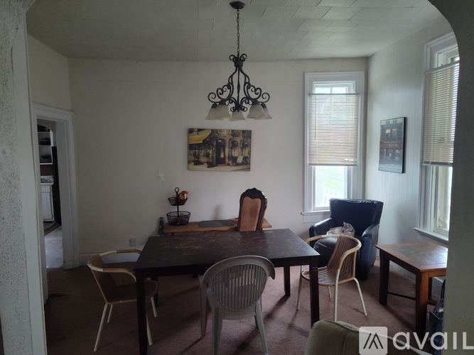 A dining room with a table and chairs.