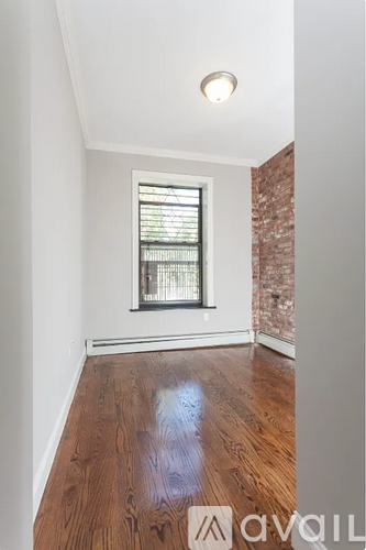 A room with a window and wooden floors.