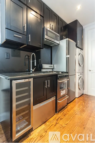 A kitchen with black cabinets and stainless steel appliances.