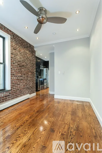 A room with a ceiling fan and wooden flooring.