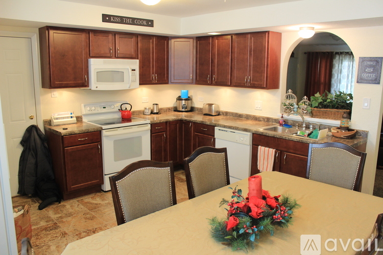 A kitchen with brown cabinets and a table set for a meal.