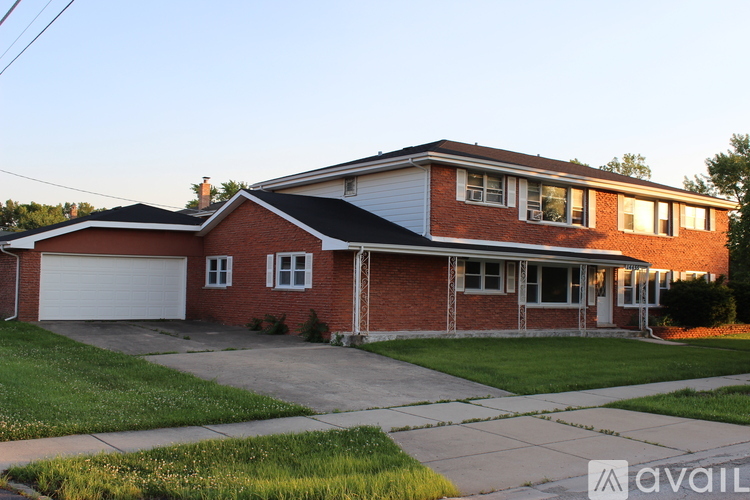 A house with a red brick exterior and a white garage door.