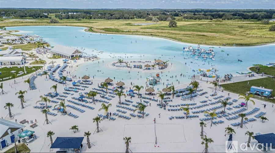 A beach resort with a large pool and many sun loungers.