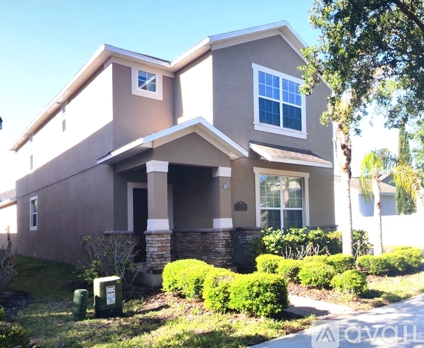 A two-story house with a front porch and a garage door.