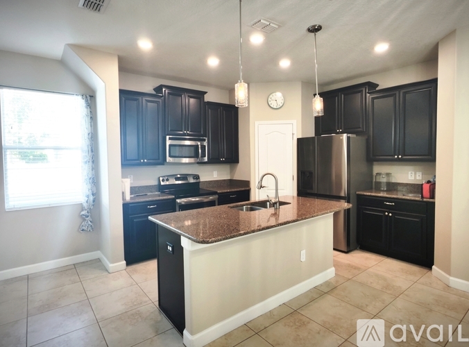 A kitchen with black cabinets and a granite countertop.