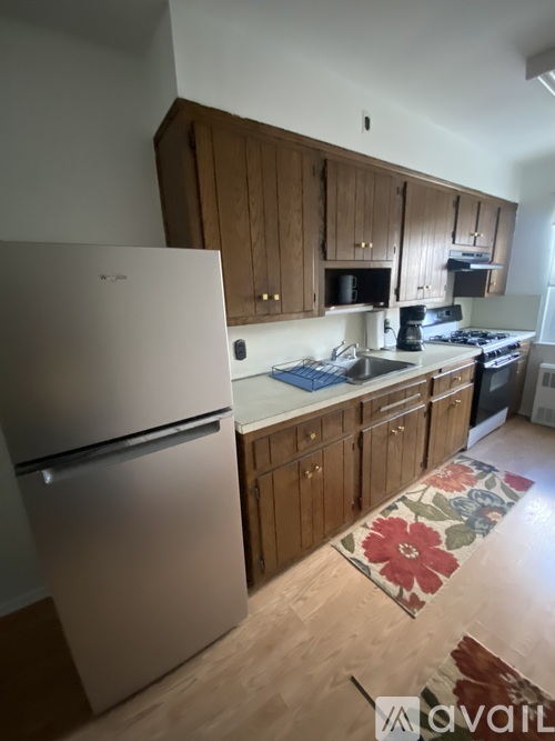 A kitchen with wooden cabinets and a white fridge.