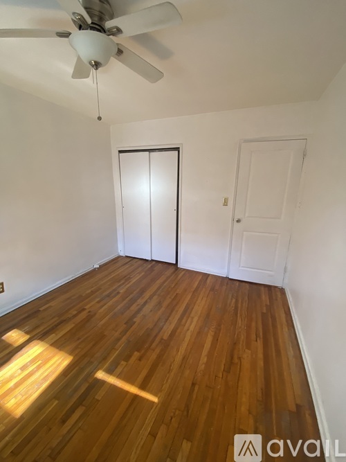 A room with wooden floors and a ceiling fan.