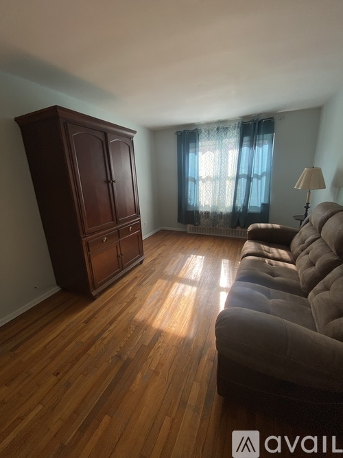 A living room with a brown cabinet and a grey couch.