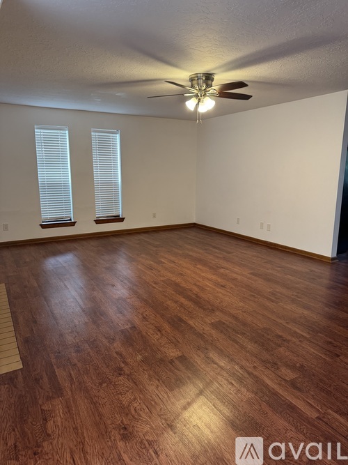 A room with wooden flooring and a ceiling fan.