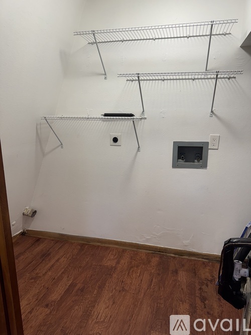 Empty room with shelves and a small box on the floor.