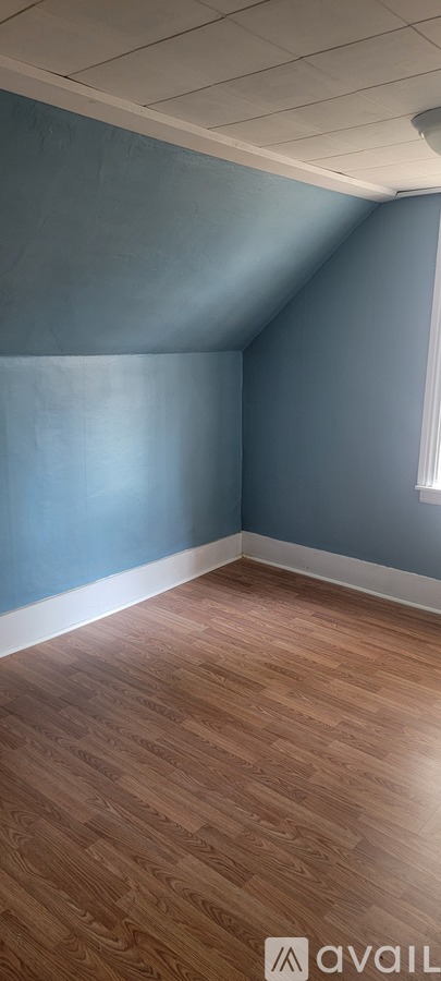 A room with wooden flooring and blue walls.