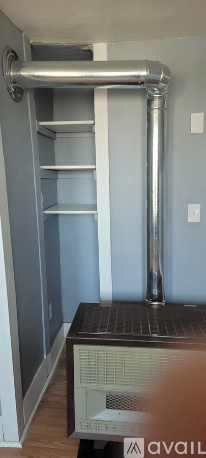 A white wall with a silver pipe running along it.