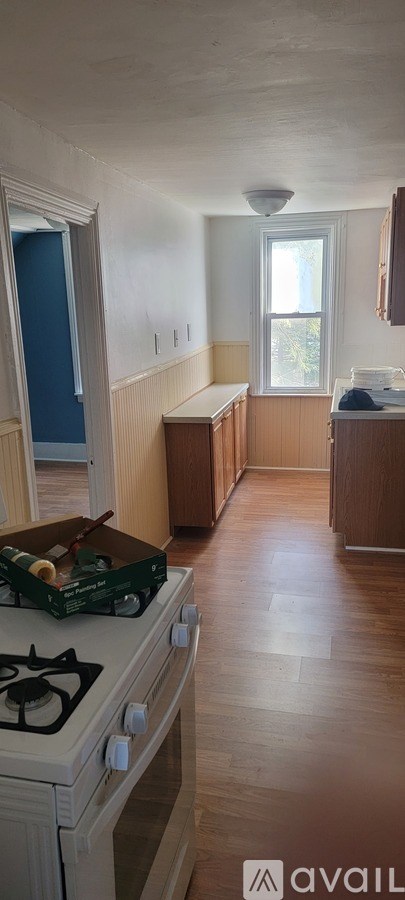 A kitchen with a white stove top oven and a window.