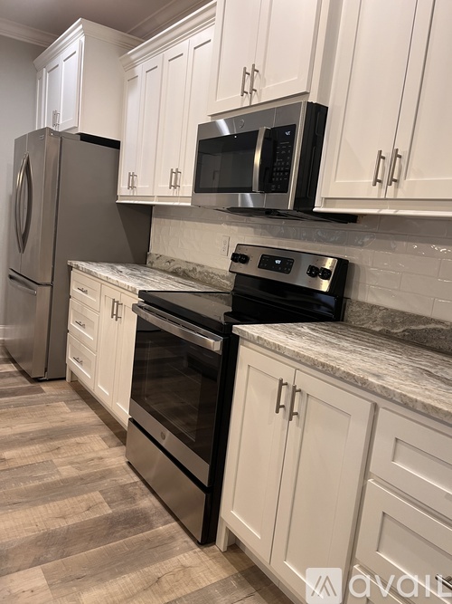 A kitchen with white cabinets and a black stove top oven.