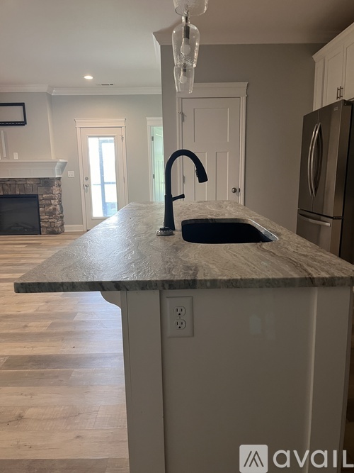 A kitchen island with a sink and a modern faucet.