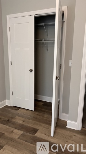 A white door is open to a small closet.