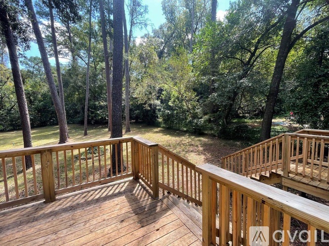 A wooden deck overlooks a wooded area.