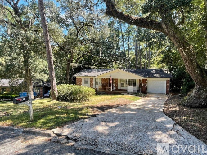 A house with a driveway surrounded by trees.